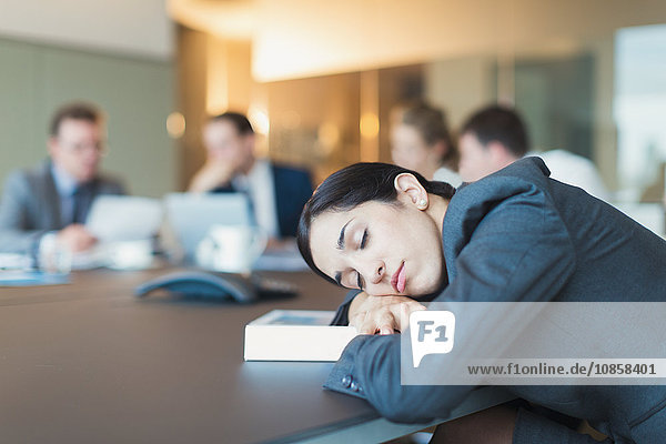 Geschäftsfrau schläft in Konferenzraumbesprechung