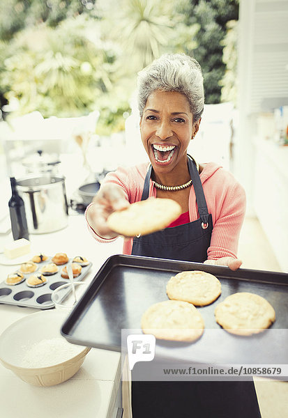 Portrait begeisterte reife Frau beim Kekse backen in der Küche