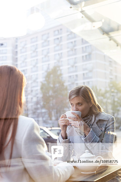 Frauen trinken Tee im Straßencafé