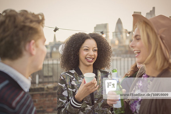 Young adult friends drinking and enjoying rooftop party