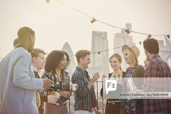 Young adult friends drinking and enjoying rooftop party