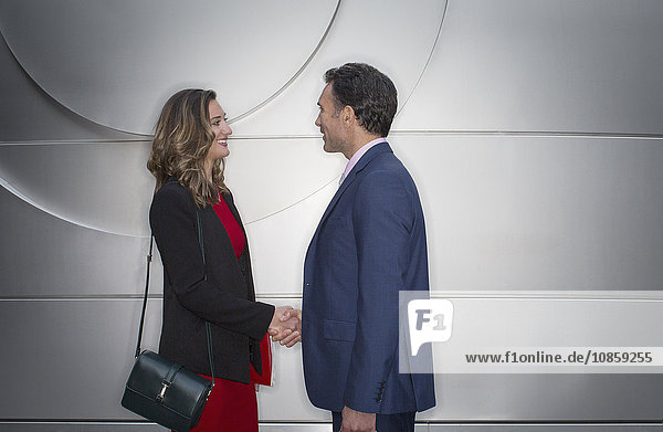 Corporate businessman and businesswoman handshaking