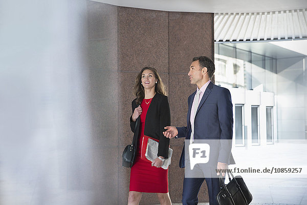 Corporate businessman and businesswoman talking and walking outdoors