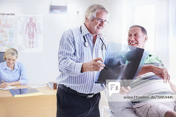 Arzt mit Röntgenaufnahme des älteren Mannes