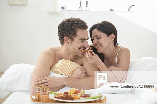 Junges Paar frühstückt im Bett