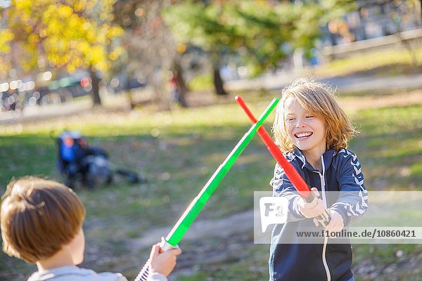 Zwei junge Brüder  spielen den Kampf mit Laserschwertern