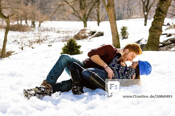 Romantisches junges Paar im verschneiten Central Park liegend  New York  USA
