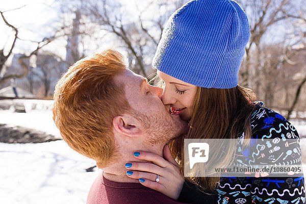 Romantic young couple kissing in snowy Central Park  New York  USA
