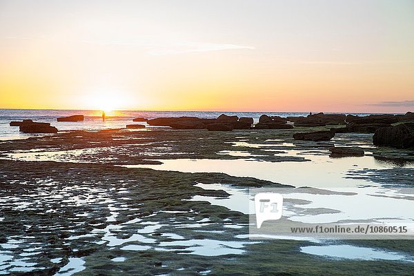 Distant view of woman at sunset on rocky beach Cape of Trafalgar Spain