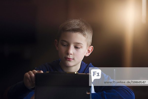 Junge benutzt drahtloses digitales Tablet zu Hause