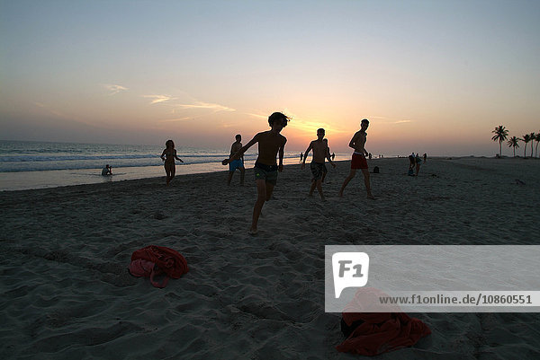 Kinder und Jugendliche spielen Fußball am Strand  Salala Beach  Oman  Asien