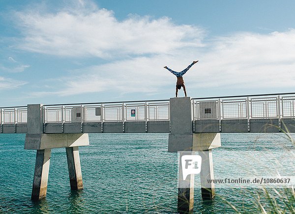 Man doing handstand on bridge South Pointe Park South Beach Miami Florida USA