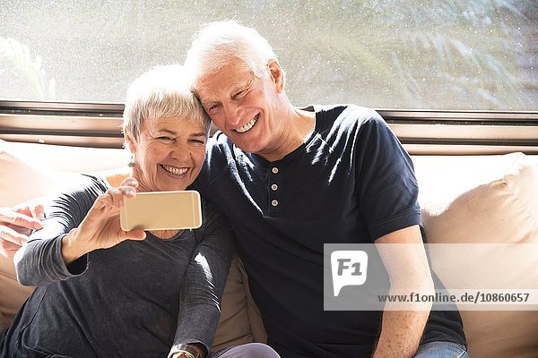 Älteres Ehepaar  auf dem Sofa sitzend  Selbstporträt  mit Smartphone