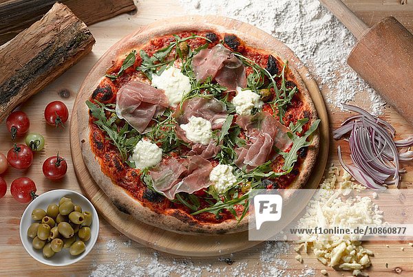 Draufsicht auf Parmaschinken-Pizza mit grünen Oliven
