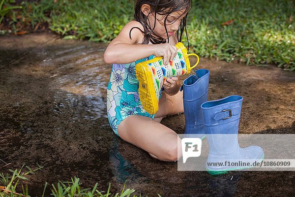 Girl filling wellies with water