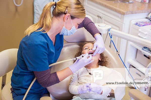 Hochwinkelansicht eines Mädchens auf einem Zahnarztstuhl bei einer zahnärztlichen Untersuchung