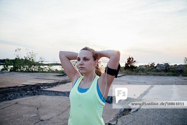 Woman wearing earbuds and activity tracker looking away