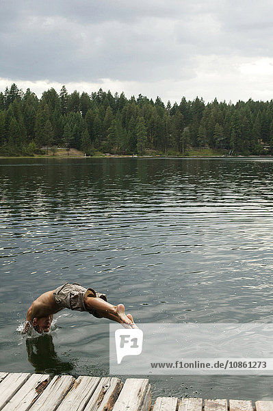Man in mid air diving into lake