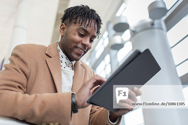 Young businessman in train station using digital tablet touchscreen
