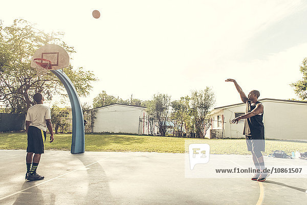 Men on basketball court scoring basketball hoops