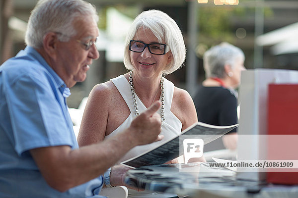 Älterer Mann und Frau lesen Speisekarte im Straßencafé
