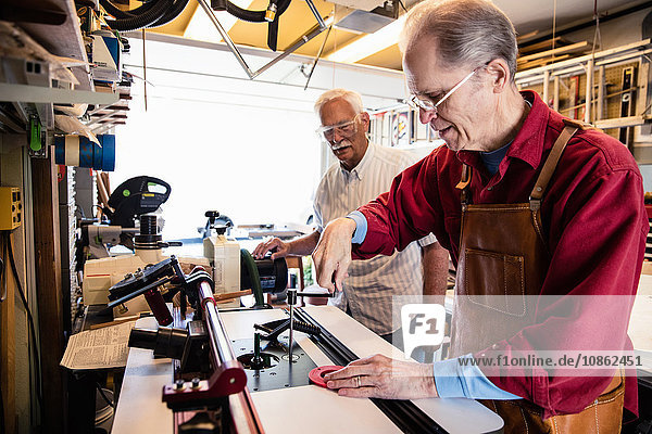 Ältere Männer  die mit der Werkstatt für Tischlereiausrüstung arbeiten