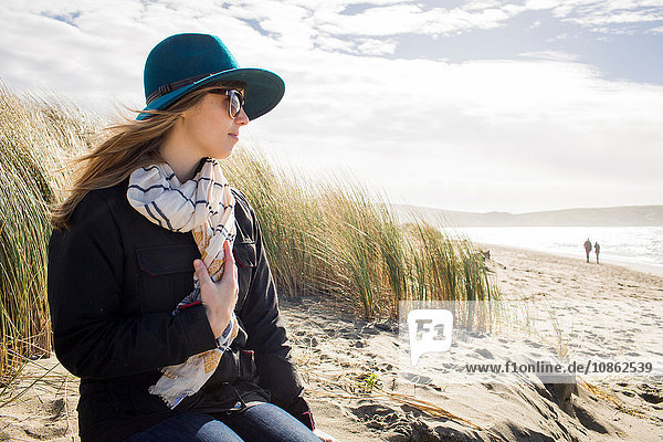 Frau mit Filzhut und Sonnenbrille mit Blick aus den Dünen  Dillon Beach  Kalifornien  USA