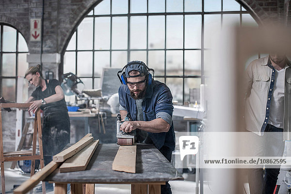 Zimmermann schleift Holz in einer Antiquitäten-Restaurierungswerkstatt
