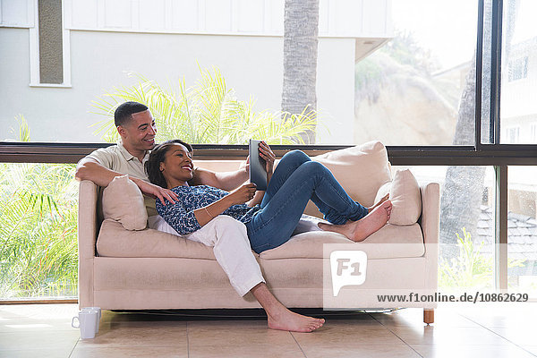 Couple reading book on sofa