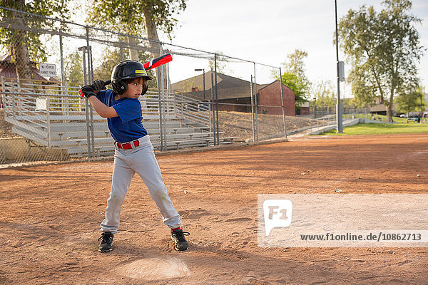 Junge schlägt beim Training auf dem Baseballfeld