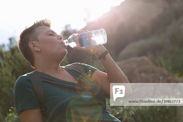 Frau trinkt Wasser aus Plastikflasche