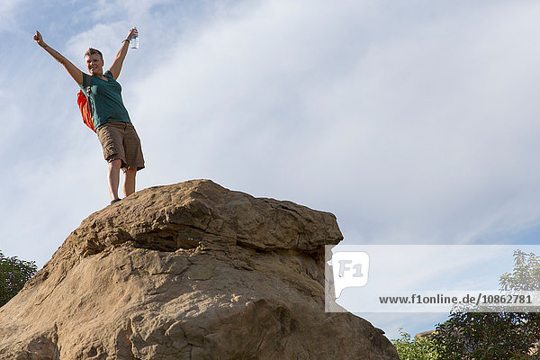 Wanderfrau auf dem Gipfel eines Felsens Arme erhoben
