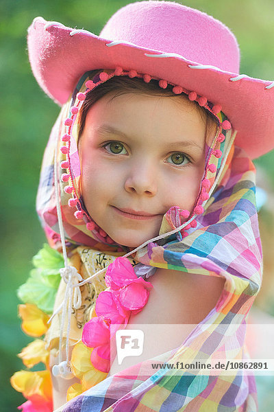 Porträt eines Mädchens mit rosa Cowboyhut im Garten