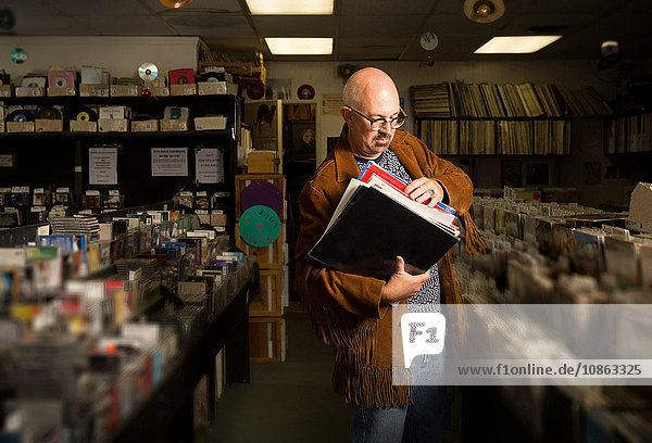 Mature man in record shop  sorting through records