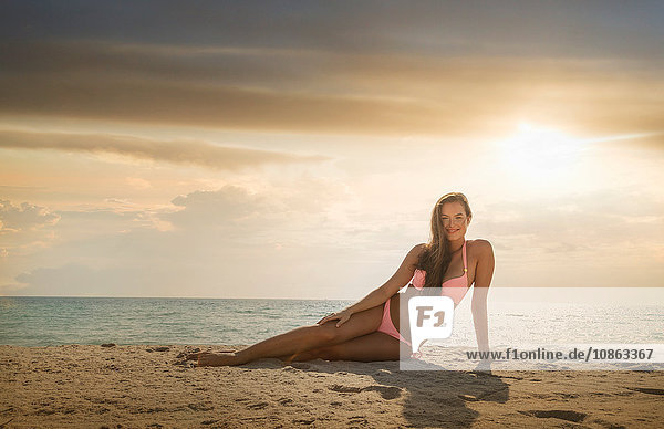 Porträt einer jungen Frau im Bikini beim Entspannen am Strand von Miami  Florida  USA