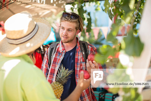 Tourist kauft Obst vom Markthändler