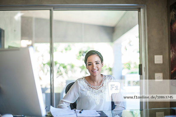 Porträt einer jungen Geschäftsfrau am Bürotisch