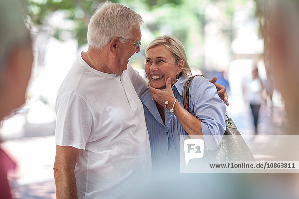 Senior man and woman laughing together in city