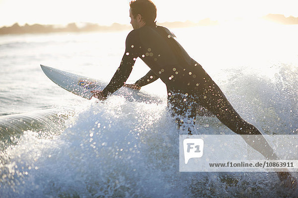 Männlicher Surfer surft in die Meereswelle am Venice Beach Kalifornien USA