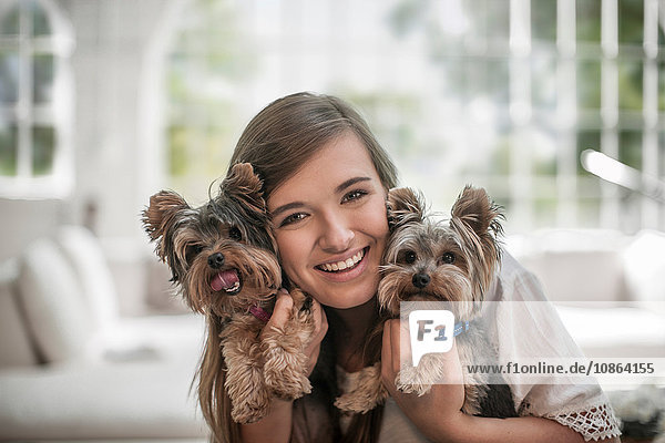 Happy woman hugging pet dogs at home