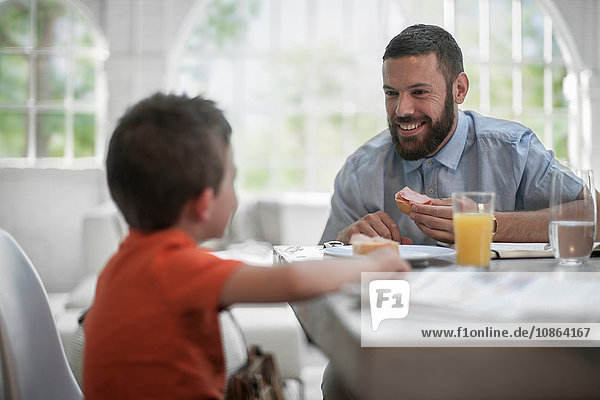 Father and son chatting at dining table