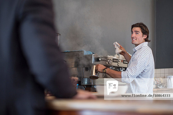 Barista macht Kaffee für Kunden im Café
