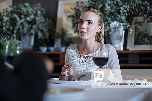 Frau speist und plaudert mit Freundin im Restaurant