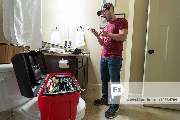 Mann wählt Werkzeug zur Reparatur des Badezimmers