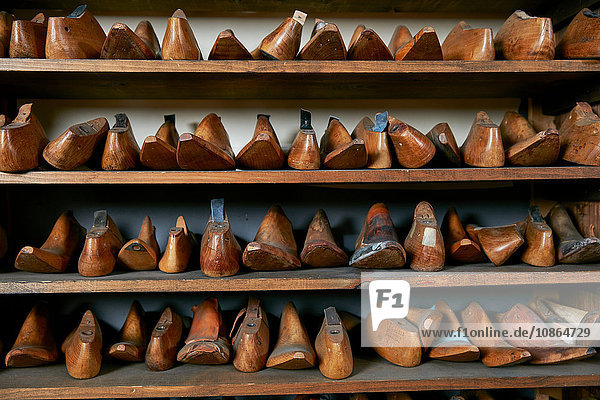 Reihen von alten Holzschuhleisten in den Regalen eines traditionellen Schuhgeschäfts  Vorderansicht