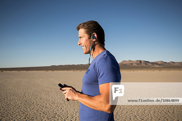 Männertraining  Bluetooth-Headset auf trockenem Seebett hören  El Mirage  Kalifornien  USA