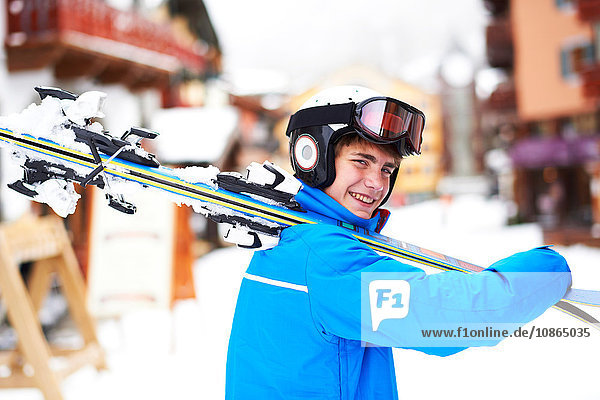 Porträt eines Teenagers  der Skier auf der Schulter trägt