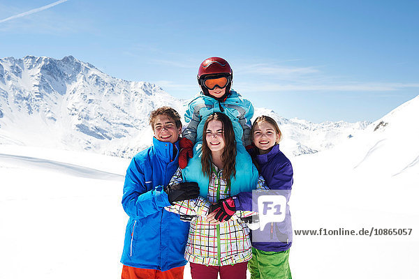 Portrait of four siblings wearing ski-wear