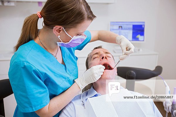 Zahnarzt führt zahnärztliche Untersuchung am reifen Mann durch