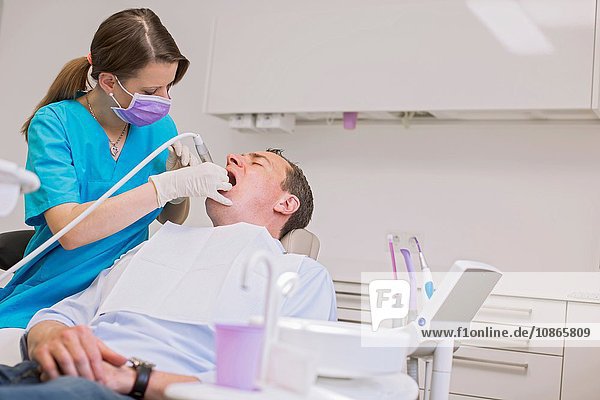 Zahnarzt führt zahnärztliche Untersuchung am reifen Mann durch